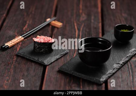 Gunkan Maki Sushi mit Fischlachs, Jakobsmuscheln, Barsch, Aal, Garnelen und Kaviar auf Holztisch. Sushi-Menü. Japanische Sushi-Set-Gunkans Stockfoto