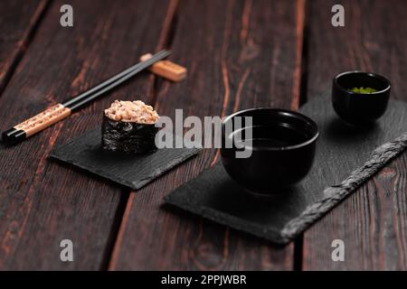 Gunkan Maki Sushi mit Fischlachs, Jakobsmuscheln, Barsch, Aal, Garnelen und Kaviar auf Holztisch. Sushi-Menü. Japanische Sushi-Set-Gunkans Stockfoto