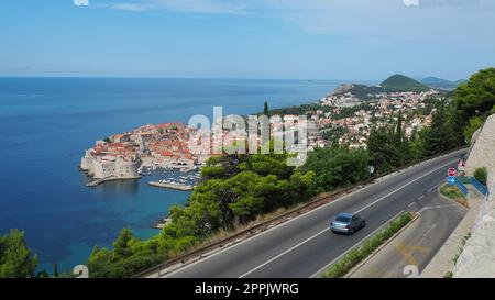 Straßenverkehr in der Nähe der Altstadt von Dubrovnik in Kroatien. Dubrovnik Ragusa ist eine Stadt in Kroatien, dem Verwaltungszentrum des Bezirks Dubrovnik-Neretva. Blick von oben von der Aussichtsplattform auf den Felsen. Stockfoto