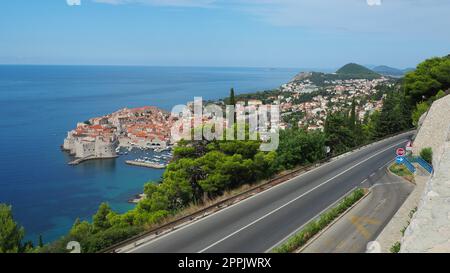 Straßenverkehr in der Nähe der Altstadt von Dubrovnik in Kroatien. Dubrovnik Ragusa ist eine Stadt in Kroatien, dem Verwaltungszentrum des Bezirks Dubrovnik-Neretva. Blick von oben von der Aussichtsplattform auf den Felsen. Stockfoto