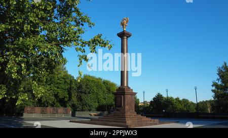 Petrozavodsk, Karelien, 3. August 2022 Monument-Stele Stadt des militärischen Ruhms, Ehrentitel. Granitsäule mit einem bronzefarbenen Adler. Podest auf der Gasse der Schwesterstädte, Kirov Square Stockfoto