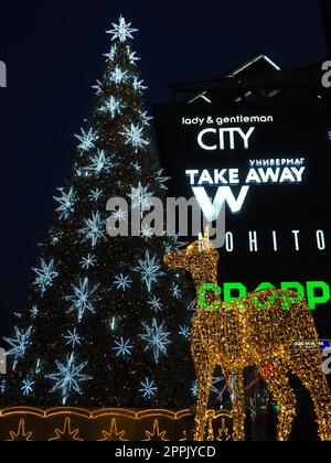 Moskau, Russland, Januar 17 2023. Straße Weihnachtsbaum mit Schneeflocken und festlichen Bällen. U-Bahn Yugo-Zapadnaya. Weihnachtsdekorationen vor dem Einkaufszentrum. Silberne Sterne, Schneeflocken und goldene Hirsche Stockfoto