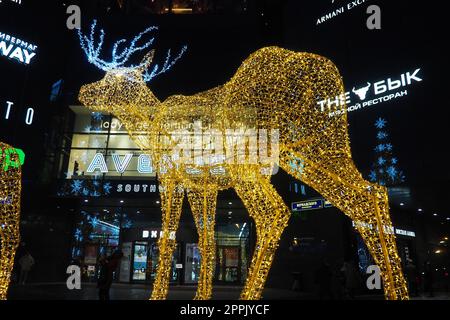 Moskau, Russland, Januar 17 2023 Metro Yugo-Zapadnaya. Weihnachtsdekorationen vor dem Einkaufszentrum. Silvester-Straßendekoration in Form von glitzernden Hirschen. Hirschfigur aus gelben Goldgirlanden. Stockfoto