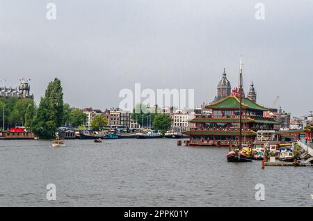 AMSTERDAM, NIEDERLANDE - 24. AUGUST 2013: Blick auf Amsterdam mit Fluss und Booten, in der Nähe des Hauptbahnhofs Stockfoto