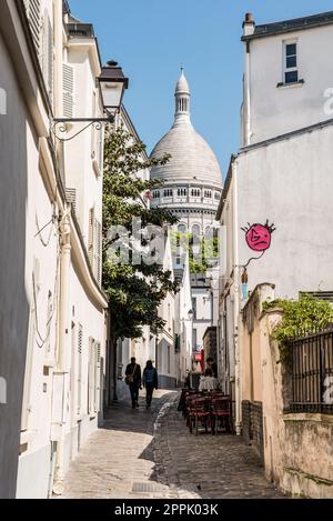 Ein Paar, das durch eine Gasse zur Kirche Sacre Coeur in Paris geht Stockfoto