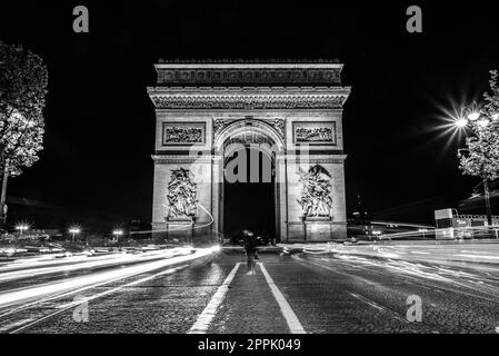 Nächtlicher Verkehr auf den Champs-Elysées, Arc de Triomph im Hintergrund Stockfoto