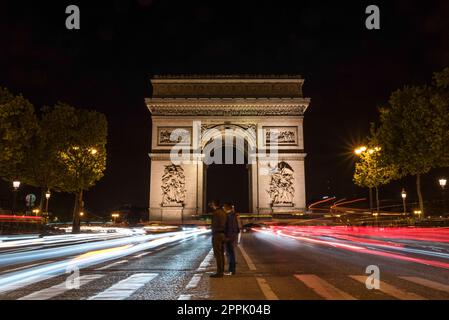 Nächtlicher Verkehr auf den Champs-Elysées, Arc de Triomph im Hintergrund Stockfoto
