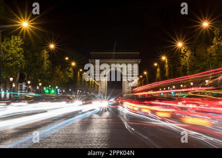 Nächtlicher Verkehr auf den Champs-Elysées, Arc de Triomph im Hintergrund Stockfoto