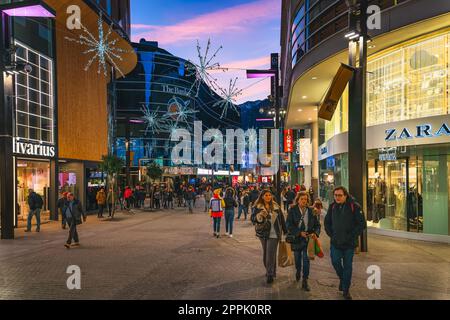 Viele Leute kaufen zollfrei auf der Straße ein, mit modernen Geschäften am Abend, Andorra Stockfoto