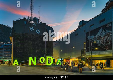 Die Leute beobachten die berühmten Neonbriefe, die sich nachts ein Schild in Andorra bilden Stockfoto