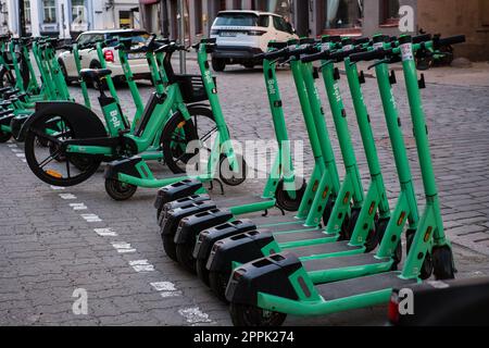 Tallinn, Estland - 21. April 2023: Bolt-Elektroroller. Geparkte grüne elektrische Leihfahrräder in einer Straße der Stadt. Stockfoto