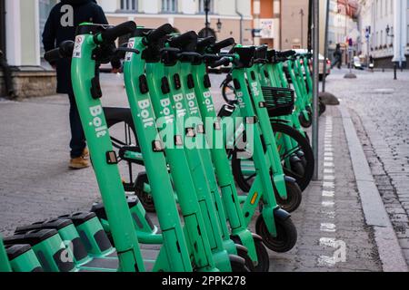 Tallinn, Estland - 21. April 2023: Bolt-Elektroroller. Geparkte grüne elektrische Leihfahrräder in einer Straße der Stadt. Stockfoto