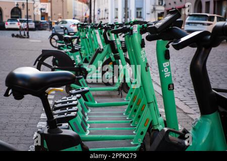 Tallinn, Estland - 21. April 2023: Bolt-Elektroroller. Geparkte grüne elektrische Leihfahrräder in einer Straße der Stadt. Stockfoto