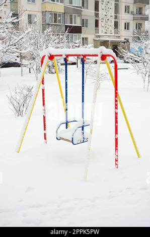 Kinderschaukel, bedeckt mit einer dicken Schneeschicht nach einem schweren Schneefall Stockfoto