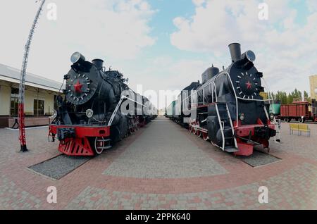Foto von alten schwarzen Dampflokomotiven der Sowjetunion. Starke Verzerrung aus dem Fischaugenobjektiv Stockfoto