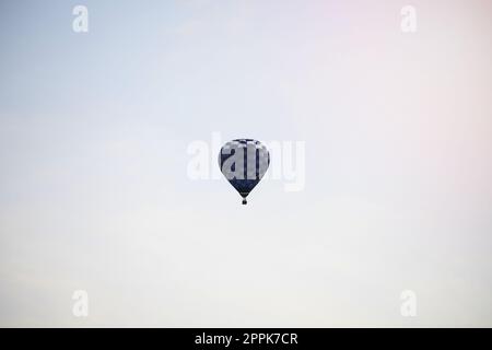 Blauer Heißluftballon, der am Himmel fliegt Stockfoto