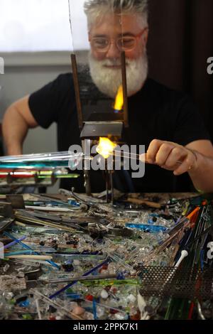 Glasarbeiter beim Formen des Glases mit einer sehr heißen Flamme Stockfoto