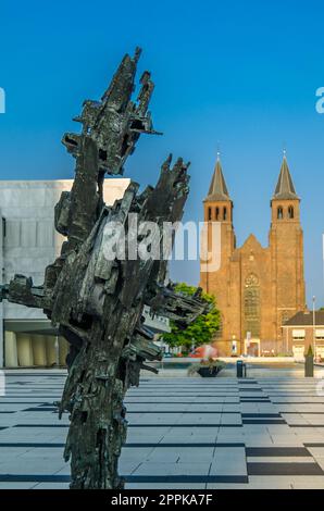 ARNHEM, NIEDERLANDE - 23. AUGUST 2013: Urbane Szene, Blick auf die moderne Skulptur â€œEvolutionâ€, von Piet Slegers ab 1969 vor dem Rathaus und der St. Walburgis-Kirche im Hintergrund Stockfoto