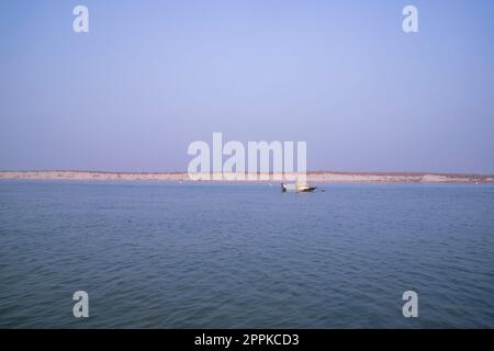 Landschaftsblick auf den Fluss Padma auf einem Fischerboot mit einer Sandinsel unter dem blauen Himmel Stockfoto