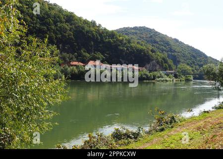 Mali Zvornik, Serbien, 29. September 2022. Fluss Drina in der Nähe von Banja Koviljaca, Blick auf die Küste Serbiens von BiH. Der Fluss des Wassers, grün am gegenüberliegenden Ufer des Flusses. Wohnhäuser. Stockfoto