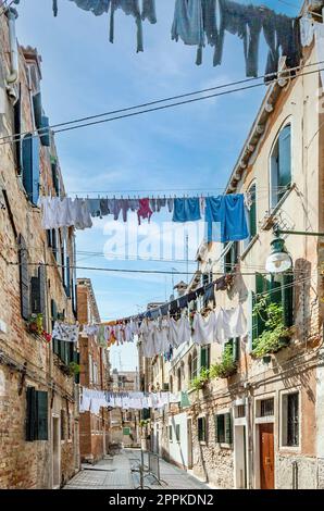 Kleidung an einer Wäscheleine in einer engen Straße in Venedig Stockfoto