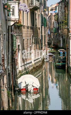 Schmaler Kanal in venedig mit Parkbooten Stockfoto