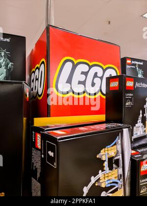 Kiel, Deutschland - 11. Februar 2023: LEGO-Logo zwischen Spielzeugschachteln. Stockfoto