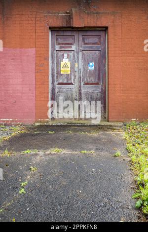 Alte Holzpaneeltür an einer elektrischen Unterstation Stockfoto
