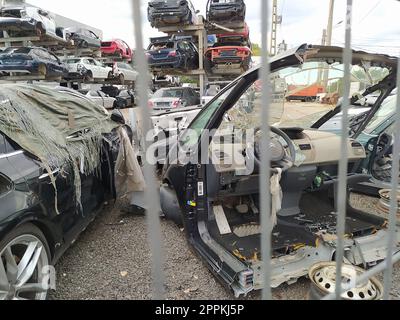 Buzau, Rumänien - 12. September 2022: Alte zerstörte Autos auf dem Schrottplatz, die darauf warten, in einem Recyclingpark in der Nähe von Bacau in Rumänien geschreddert zu werden. Stockfoto