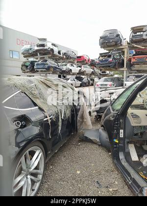 Buzau, Rumänien - 12. September 2022: Alte zerstörte Autos auf dem Schrottplatz, die darauf warten, in einem Recyclingpark in der Nähe von Bacau in Rumänien geschreddert zu werden. Stockfoto