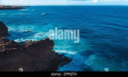 Luftaufnahmen von der Drohne: Portugiesische Felsenküste mit wunderschönem Meerblick. Sie fliegen über Portugal, die Küste, die Ozeanwellen Rollen, stürzen ab Stockfoto