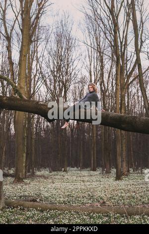 Anmutige Frau, die sich auf dem Fallschirm über Blumen ausruht, malerische Fotografie Stockfoto