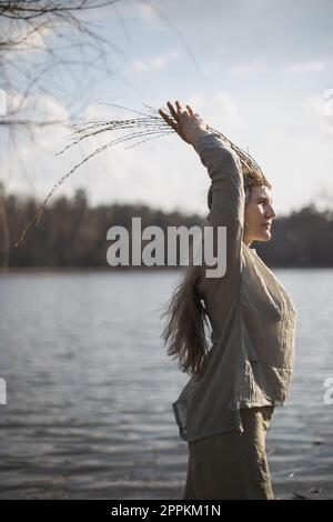 Nahaufnahme einer authentischen Frau, die sich vor dem See in einem Porträtbild von heidnischen Outfits posiert Stockfoto