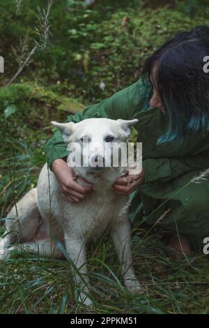 Nahaufnahme Frau umarmt weißen süßen Bastard im Wald Konzeptfoto Stockfoto