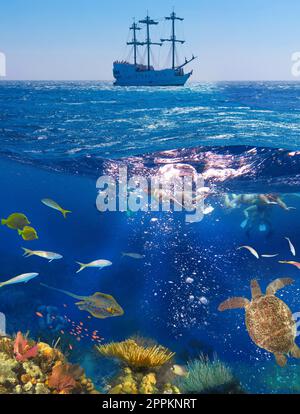 Yacht und Unterwasser mit Fischen und Korallen - farbenfrohe tropische Fische am Riff auf See. Farbenfrohes Korallenriff mit vielen Fischen und Meeresschildkröten. Die Leute bei der Schnorcheltour Stockfoto