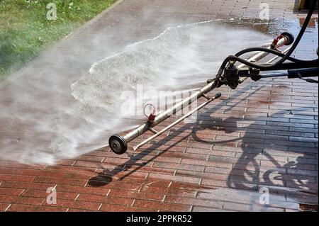 Eine spezielle Maschine wäscht Stadtwege und Straßen mit Wasser Stockfoto