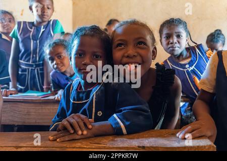 Fröhliche madagassische Schulkinder im Klassenzimmer. Der Schulbesuch ist obligatorisch, aber viele Kinder gehen nicht zur Schule. Stockfoto