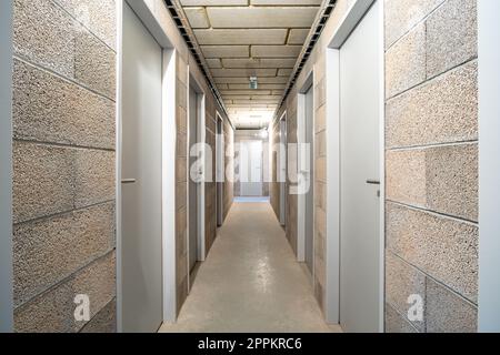 Untergeschossfläche in einem neuen Apartmentgebäude. Korridor mit einer Tür Stockfoto