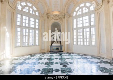 Venaria reale, Italien - Januar 2023: Luxuriöser Innenraum des alten Königspalastes. Galerieperspektive mit Fenster. Stockfoto