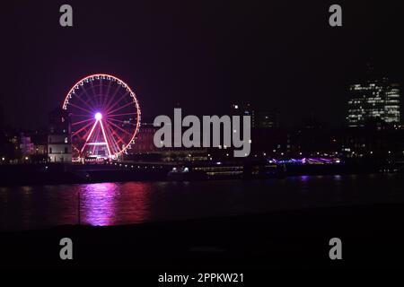 Rheinufer bei Nacht mit Burgturm und rosa Riesenrad in Düsseldorf Stockfoto
