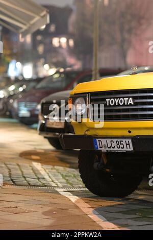Vorderansicht mit Details eines geparkten alten gelben Toyota Landcruiser in Düsseldorf Stockfoto