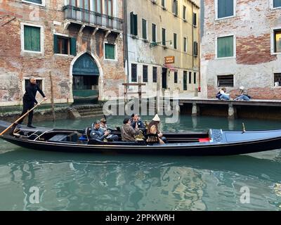 Gondel mit Touristen schwimmt entlang des Kanals in Venedig Stockfoto