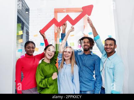 Junge fröhlich-bunten Business Team eine rote statistische Pfeil gedrückt halten. Konzept der wachsenden, erfolgreichen und Gewinn Stockfoto