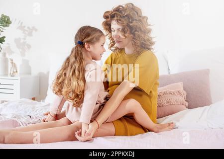 Schwangere Mutter spielt mit ihrer Tochter. Familienkonzept, Freude und Schwangerschaft Stockfoto