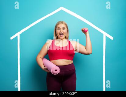 Fat Girl macht zu Hause Fitness-Studio. Zufriedener Ausdruck. Hintergrund Zyan Stockfoto