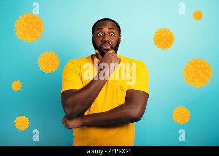 Ängstlicher Ausdruck eines Jungen, der Angst hat, das Coronavirus zu fangen. Hintergrund Zyan. Stockfoto