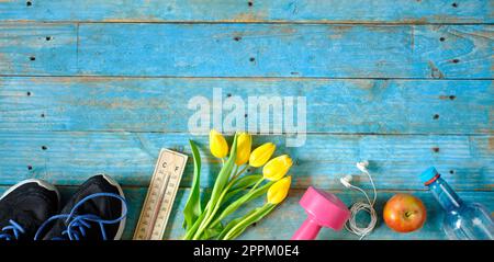 Sport und Fitness im Frühling und Sommer, flach liegend mit Sportausrüstung, Tulpen, Thermometer, Wasser und einem Apfel. Kostenloser Kopierraum, Negativraumtechnik Stockfoto