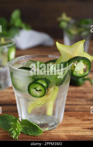 Würziger Cocktail mit Jalapeno, Karambola und Minze auf einem Holztisch Stockfoto