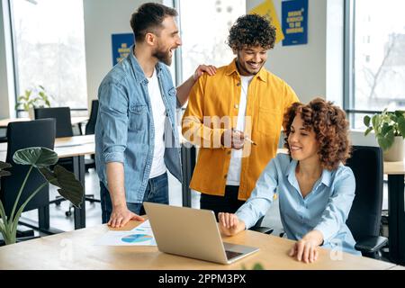 Kreatives Business-Team, erfolgreiche Menschen verschiedener Nationalitäten, die an einem Projekt in einem modernen Büro zusammenarbeiten, Präsentationen anschauen, Ideen diskutieren, Brainstorming durchführen, kommunizieren. Teamarbeit Stockfoto