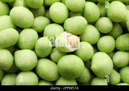 Leckere Wasabi-beschichtete Erdnüsse als Hintergrund, Draufsicht Stockfoto